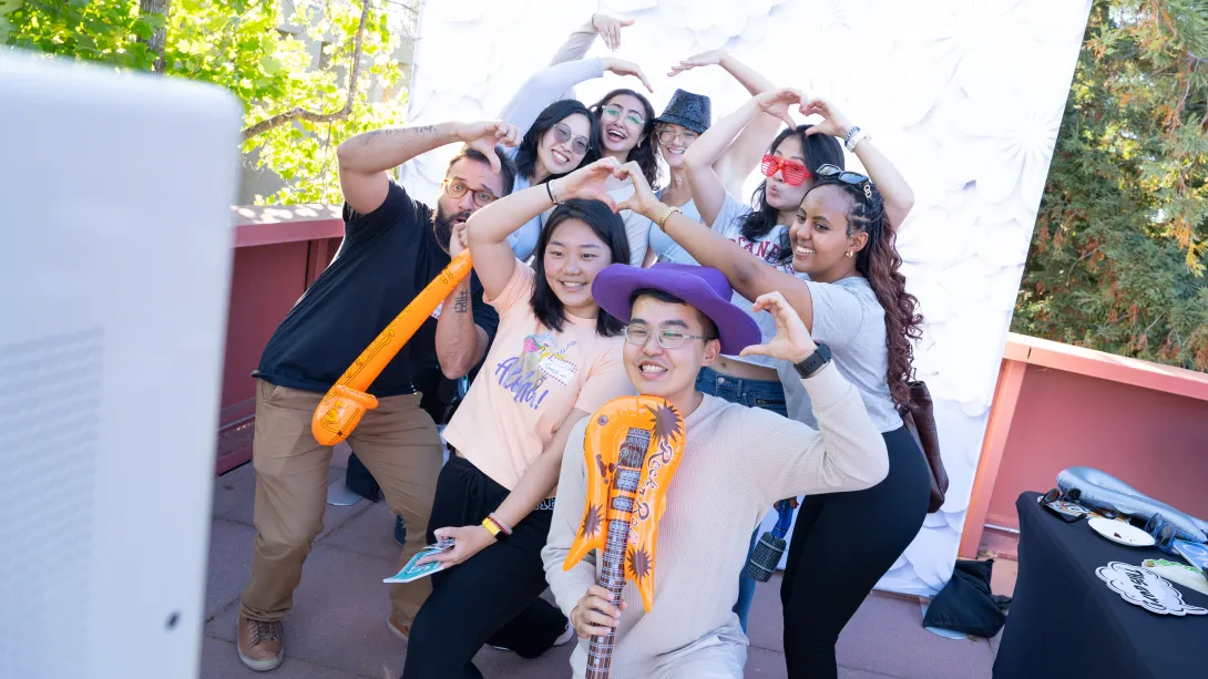 New students pose with props at the photo booth station during the dean’s fall kickoff barbecue event.